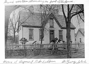 Grandmother standing in front of the home. Home of Agnes Elizabeth Perkes Calkins. St. George, Utah.